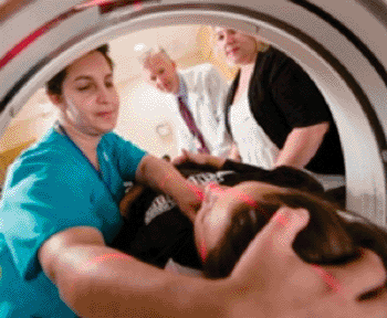 Image: Technologist Diane Lemieux follows the red guide lights as she adjusts her patient’s head for a pediatric CT scan. When a CT scan is still the best alternative, careful planning goes into minimizing radiation (Photo courtesy of Robert Lisak).